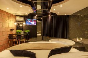 a bathroom with a tub and a tv in a room at Motel Paradiso - Panambi-RS in Tabapira