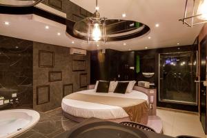 a bedroom with a bed and a tub and a sink at Motel Paradiso - Panambi-RS in Tabapira