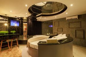 a bedroom with a large bed and a bar at Motel Paradiso - Panambi-RS in Tabapira