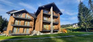 a large house with a green yard at Villa Erdődy Resort - Apartman 18 in Oravská Lesná