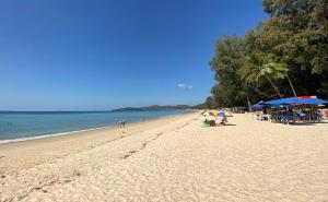 a beach with people and umbrellas and the ocean at Studio at Kris Condo walk to Bangtao beach 2304 in Bang Tao Beach