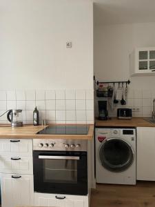 a kitchen with a stove and a washing machine at Apartment in Reudnitz in Leipzig
