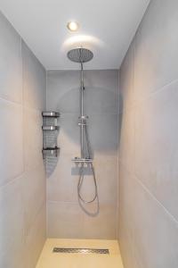 a shower with a shower head in a bathroom at Boerderijkamer Ochtendzon in Lutten