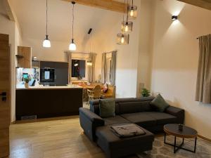 a living room with a couch and a kitchen at Neue moderne Ferienwohnung mit Infrarot Sauna und großen Garten in Hengersberg