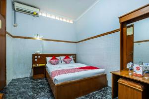 a bedroom with a bed with red and white pillows at Collection O Kebon Jeruk Near Taman Balai Kota in Bandung