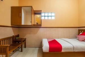 a bedroom with a bed and a sink and a mirror at Collection O Kebon Jeruk Near Taman Balai Kota in Bandung