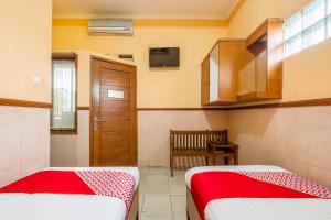 two beds in a room with a door and a window at Collection O Kebon Jeruk Near Taman Balai Kota in Bandung +23 photos