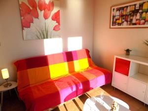 a colorful bed in a room with a table at Saint Palais sur Mer - APPARTEMENT FACE MER sur la corniche de NAUZAN in Saint-Palais-sur-Mer