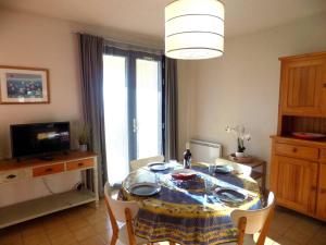 a dining room with a table and chairs and a television at Saint Palais sur Mer - APPARTEMENT FACE MER sur la corniche de NAUZAN in Saint-Palais-sur-Mer +18 photos