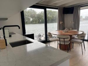 a kitchen with a table and a view of the water at The Sustainable Saek Sneekermeer in Sneek