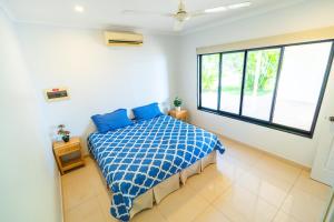 a bedroom with a bed and a large window at Bungalow 58 Lake Bennett Darwin in Lake Bennett