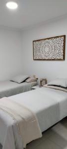 Un dormitorio con dos camas y un cuadro en la pared. en Casa Vistabella, en Costa Calma