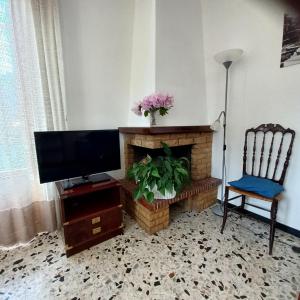 a living room with a tv and a fireplace at CASA PEONIA Lovely Flat in Moneglia