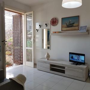 ein Wohnzimmer mit einem TV auf dem Tisch in der Unterkunft Sirleo house in Torre dell'Orso