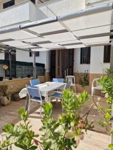eine Terrasse mit einem Tisch und Stühlen unter Markise in der Unterkunft Sirleo house in Torre dell'Orso