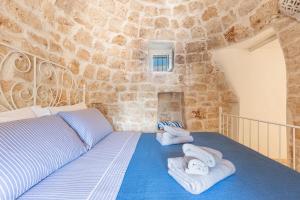 ein Schlafzimmer mit einem Bett in einer Steinmauer in der Unterkunft Trullo Isabell by Perle di Puglia in San Vito dei Normanni + 41 Fotos