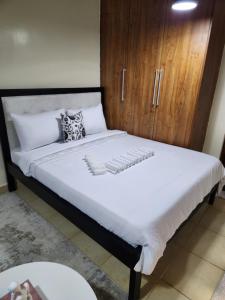 a bedroom with a large bed with a wooden cabinet at The Haven in Ongata Rongai 