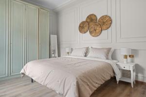 a white bedroom with a bed and a wooden floor at Maison G - new design apartment with balcony in Rome