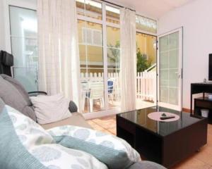 a living room with a couch and a coffee table at Gran Canaria Las Palmas Apartment in Mogán