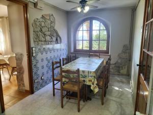 a dining room with a table and chairs and a window at Cal Japet Encant Rural in Fonollosa