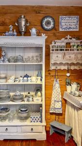 a white cabinet filled with dishes and plates at beautiful cosy Country Cottage Heaven only for You in Nowy Berezów +18 photos