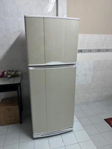 テメルローにあるNADDY HOMESTAY Temerloh Jayaの白い冷蔵庫付きのキッチン(テーブル付)
