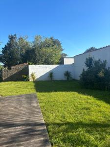 een houten loopbrug in het gras naast een gebouw bij L'Heure Bleue in Les Portes