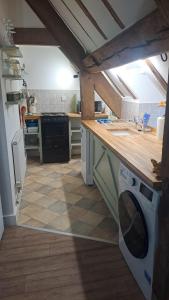 a kitchen with a sink and a stove in it at Top Floor Malthouse Studio Apartment in Much Wenlock