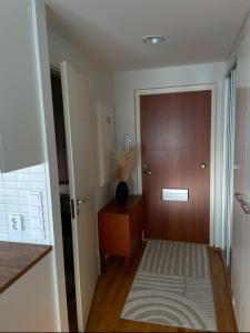 a hallway with a wooden door and a wooden table at Cozy Top-Floor Studio in Turku - Near City Center in Turku