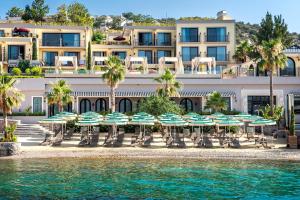 a hotel with chairs and umbrellas on the beach at Casa Nonna Bodrum - Adult Only in Bodrum City