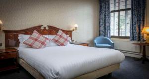 a hotel room with a large bed with pillows at Best Western Plough and Harrow Hotel in Birmingham +77 photos