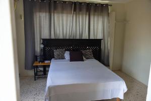 um quarto com uma grande cama branca e uma mesa em Nics Appartments - Relaxing vacation 5 min from different beaches em Dorp Sint Michiel