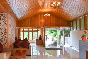a living room with a wooden ceiling and a couch at Yashshree Karbari Resort & Spa in Yangang