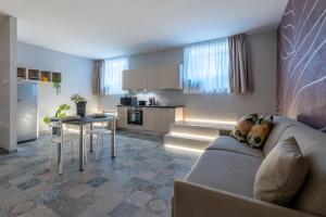 un soggiorno e una cucina con un divano e un tavolo di Duomo-Navigli - Loft Romana con Wi-Fi & Netflix a Milano Altre 14 foto