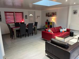 a living room with a red couch and a table at La Case Etoilée in Ostwald