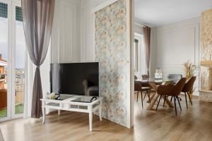a living room with a tv and a table with chairs at Maison G - new design apartment with balcony in Rome