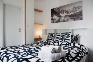 a bedroom with a black and white bed with towels on it at Seasons stay Bansko in Bansko