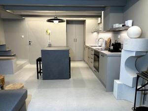 a large kitchen with a counter and a table at Loft 181 by Oikies Rentals in Neoi Epivates +15 photos