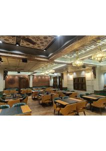 ein Esszimmer mit Tischen und Stühlen und Kronleuchtern in der Unterkunft Atithyaa in Bangalore + 29 Fotos