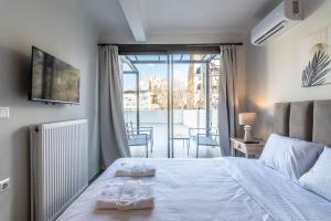 sypialnia z łóżkiem i dwoma ręcznikami na nim w obiekcie LEGAS apartments w Atenach