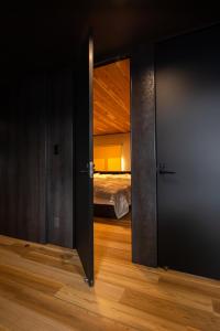 an open door to a bedroom with a bed at Jaune Chalet in Hakuba +38 photos