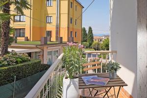 een balkon met een tafel en uitzicht op een gebouw bij PeschieraHome Apartments in Peschiera del Garda