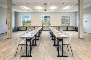 a classroom with tables and chairs in a room with windows at Park Inn by Radisson Vilnius Airport Hotel & Conference Centre in Vilnius