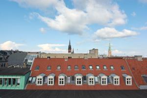 a red brick building with a clock tower in the background at Eksklusiv-nordisk-topbelligenhed in Copenhagen