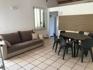 a living room with a couch and a table and chairs at HIDE by the Sea in Ortona