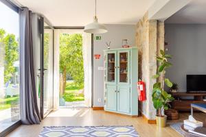 a living room with a blue cabinet and a sliding glass door at Quinta Santo António Amares in Amares