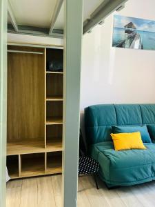 a living room with a blue couch and a book shelf at Studio Georges 1er in Aix-les-Bains