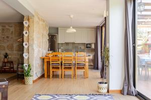a dining room and kitchen with a table and chairs at Quinta Santo António Amares in Amares
