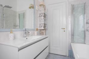 a white bathroom with a sink and a mirror at Maison G - new design apartment with balcony in Rome +34 photos