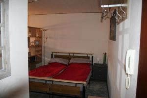a bedroom with a bed with a red blanket at Fels- und Seenland in Ludwigswinkel